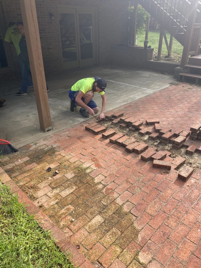 employee removing bricks for new drainage install | once & done