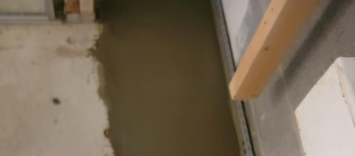 Basement area showing freshly poured concrete, illustrating the process of basement waterproofing to prevent water damage and enhance home value.