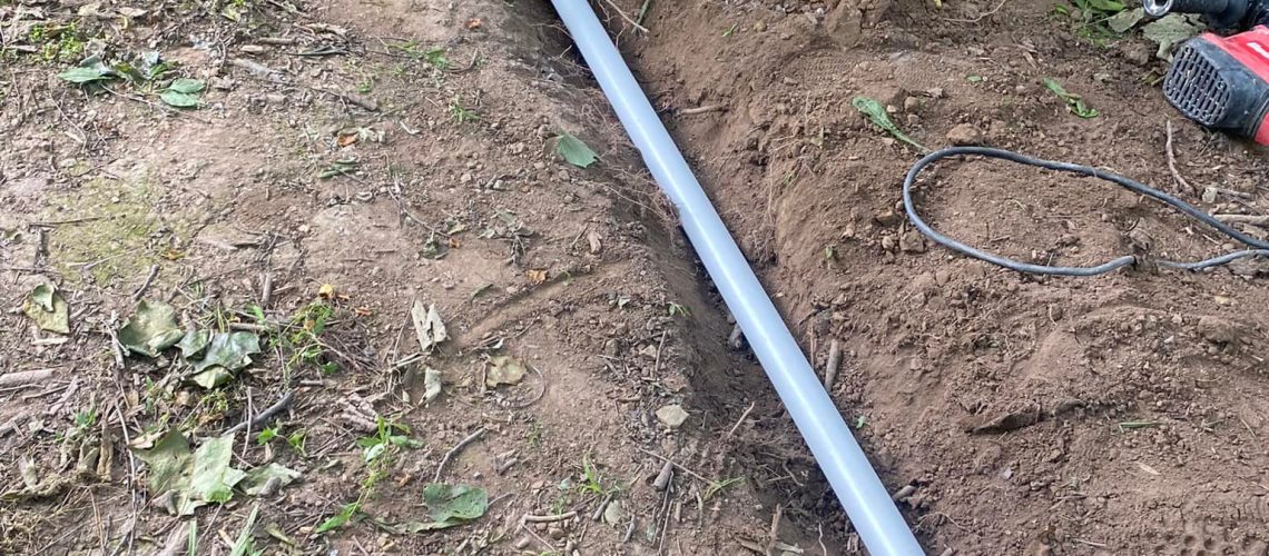 Yard with a trench dug and pipe laid inside | French Drain | Once and Done Waterproofing WV, MD, PA, NJ